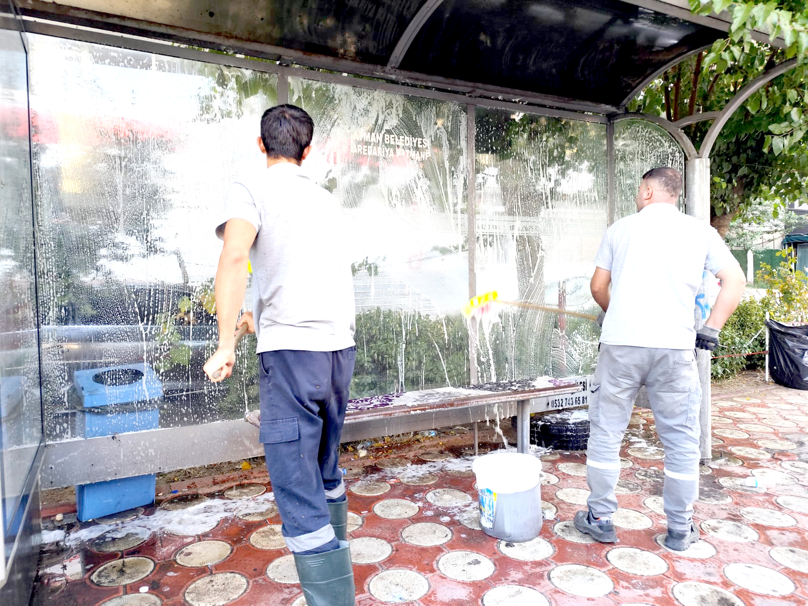 Belediye otobüs duraklarını temizliyor